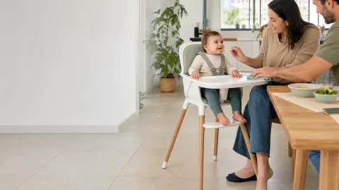 תינוק חגור בכיסא אוכל עם תמיכת רגליים